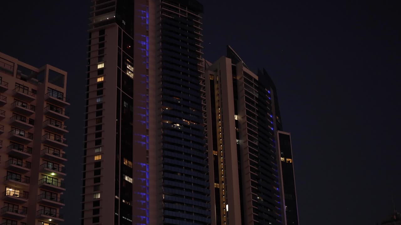 rascacielos y frente al mar por la noche con luces