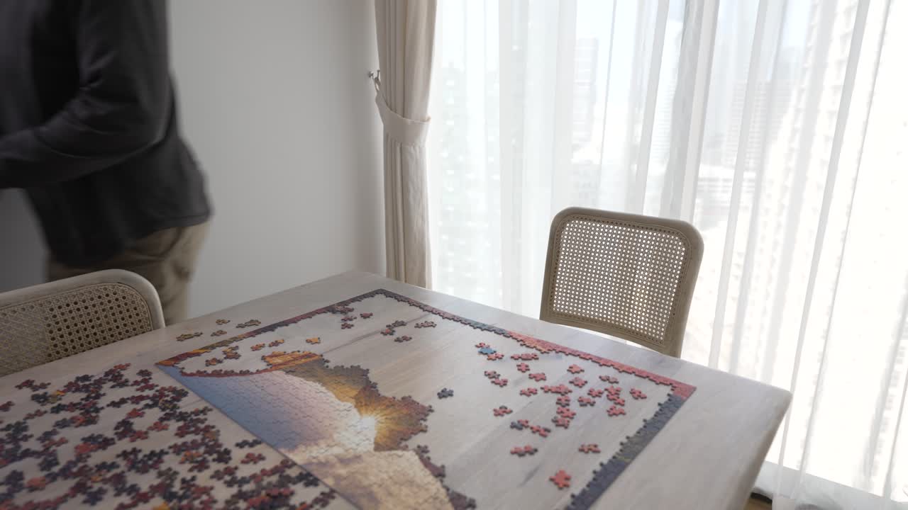 Old man gets frustrated as he tries to put pieces of a puzzle in place - pullback reveal