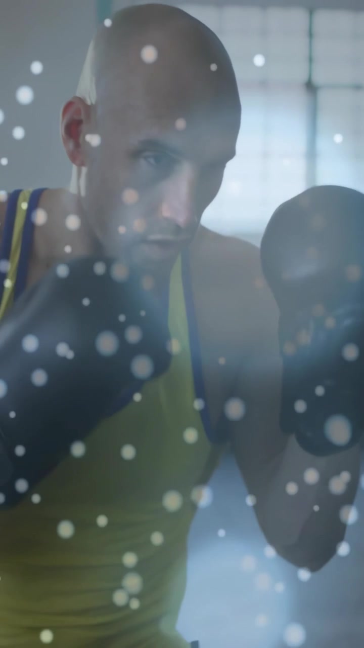 Video verticale: Pugile uomo che alza la guardia e sferra pugni durante un allenamento di boxe con i guantoni, con punti fluttuanti.
