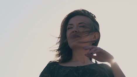 una mujer sonriente disfruta de un bonito día de primavera a la luz del sol en cámara lenta