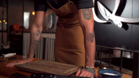 brazos de tatuaje de modelo latino masculino poner tabla de cortar en la mesa brazos abiertos