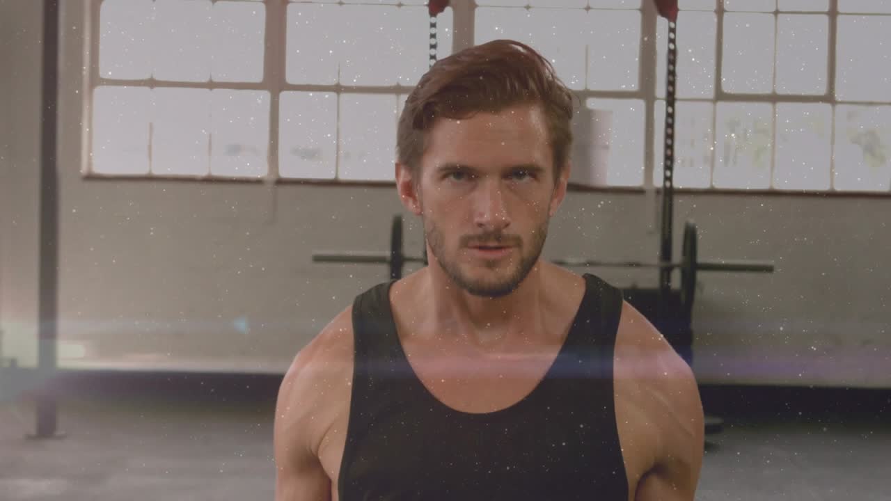 Gripping hex dumbbells, male performing controlled bicep curls in gym for strength with lens flare