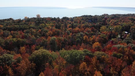 Una-Vista-Aérea-De-Alto-ángulo-Volando-Sobre-El-Follaje-Otoñal-De-Michigan