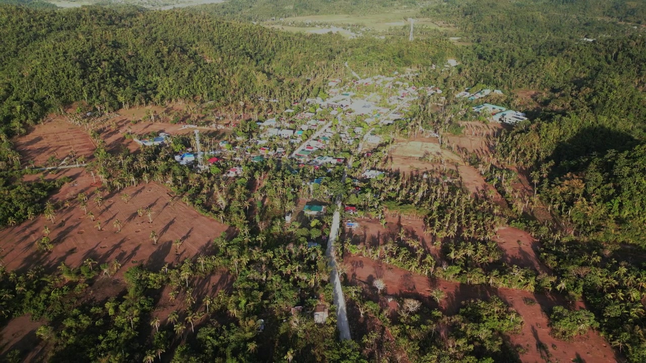 Luftoptagelse over Hawan Grande i Virac, Catanduanes, der afslører et landligt barangay-område med huse, kokoslunde og tropisk terræn.