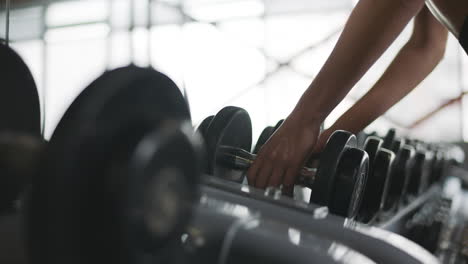 Female-hands-finishing-weight-training-in-fitness-club.