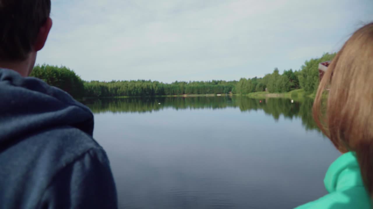 관광객 들 은 나무 다리 에 서서 숲 호수 의 전망 을 즐긴다. 강 근처 에서 휴식을 취하고 있다