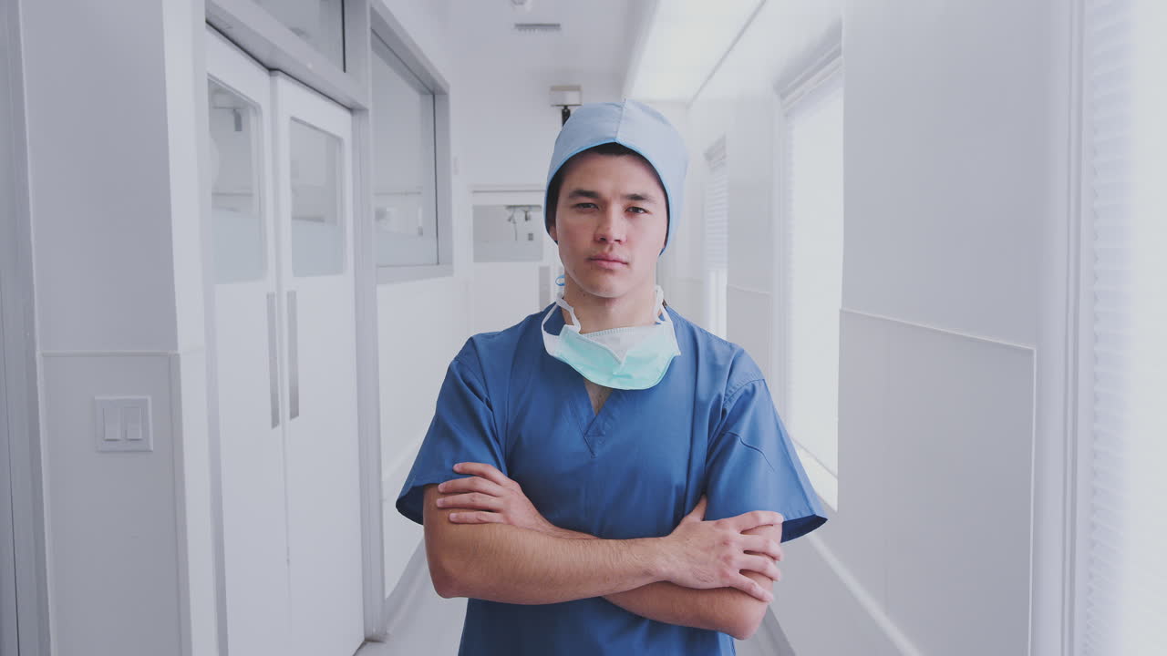병원 복도 에 서 있는 수술복 과 마스크 를 착용 한 남성 외과의사 의 초상화