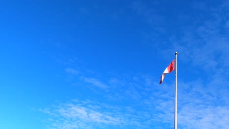 Bandera-Nacional-Canadiense-En-El-Poste-Ondeando,-Cielo-Azul-En-El-Fondo,-Vista-De-Establecimiento-De-ángulo-Bajo