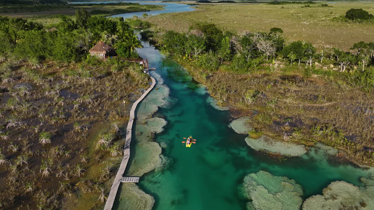 vista aérea de gente haciendo kayak en el estrecho canal de los rápidos de bacalar, en el soleado méxico