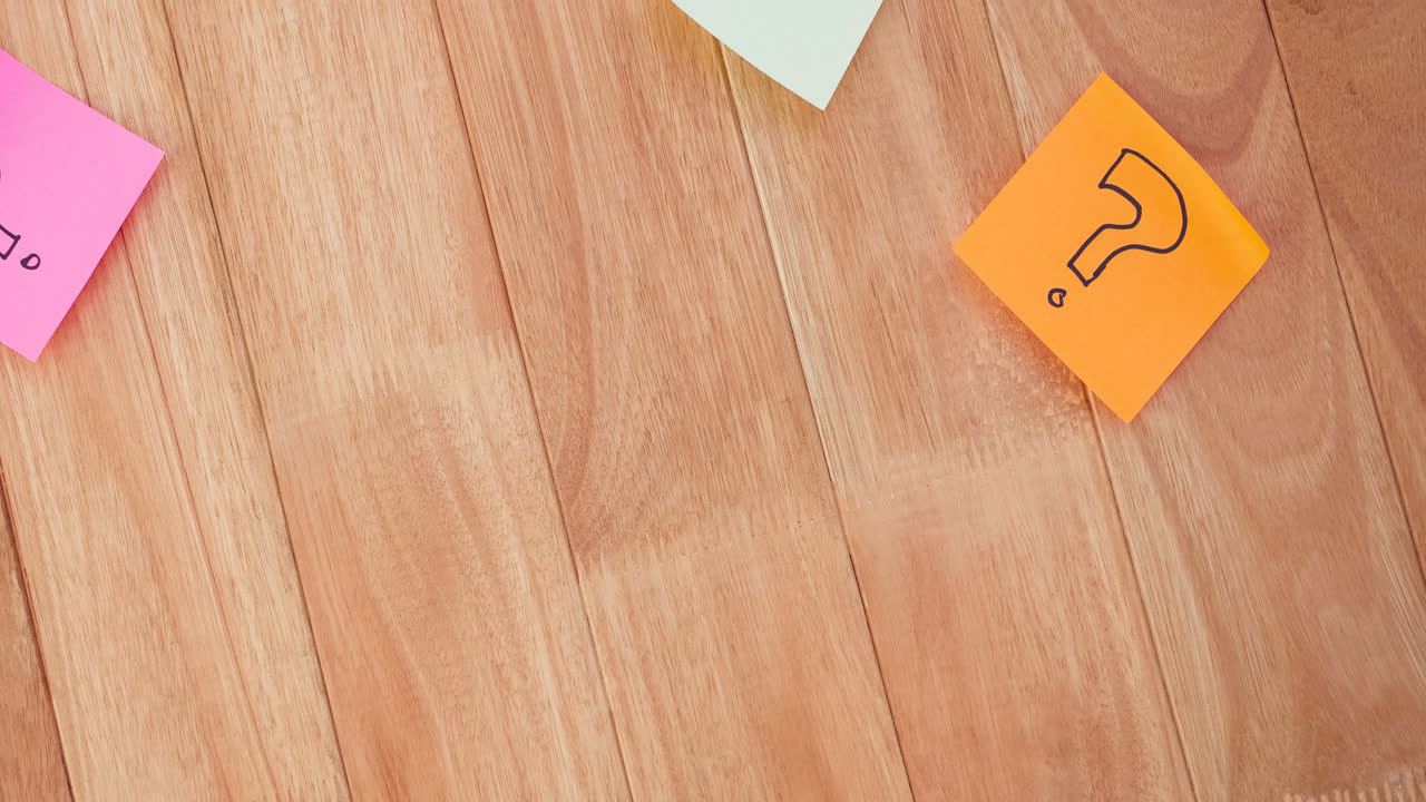Question mark signs drawn on coloured memo notes stuck on wooden boards