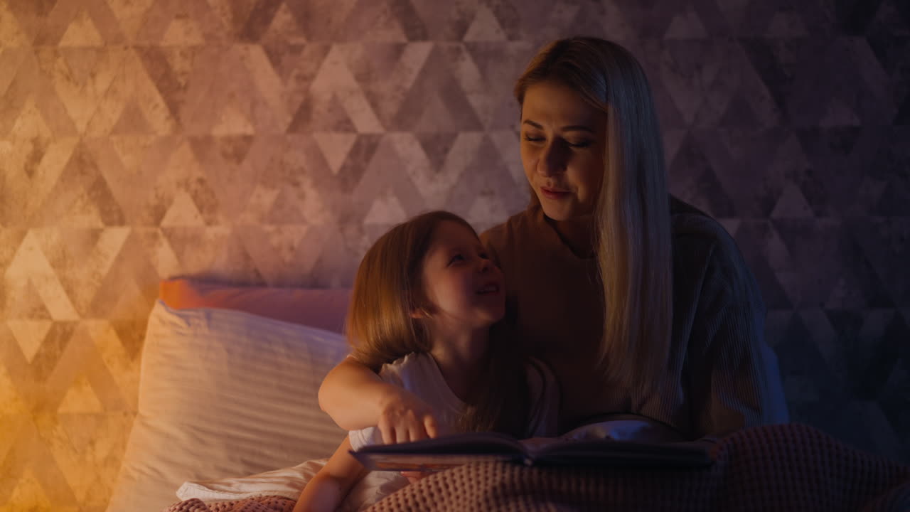 Little girl laughs listening to mommy reading funny book
