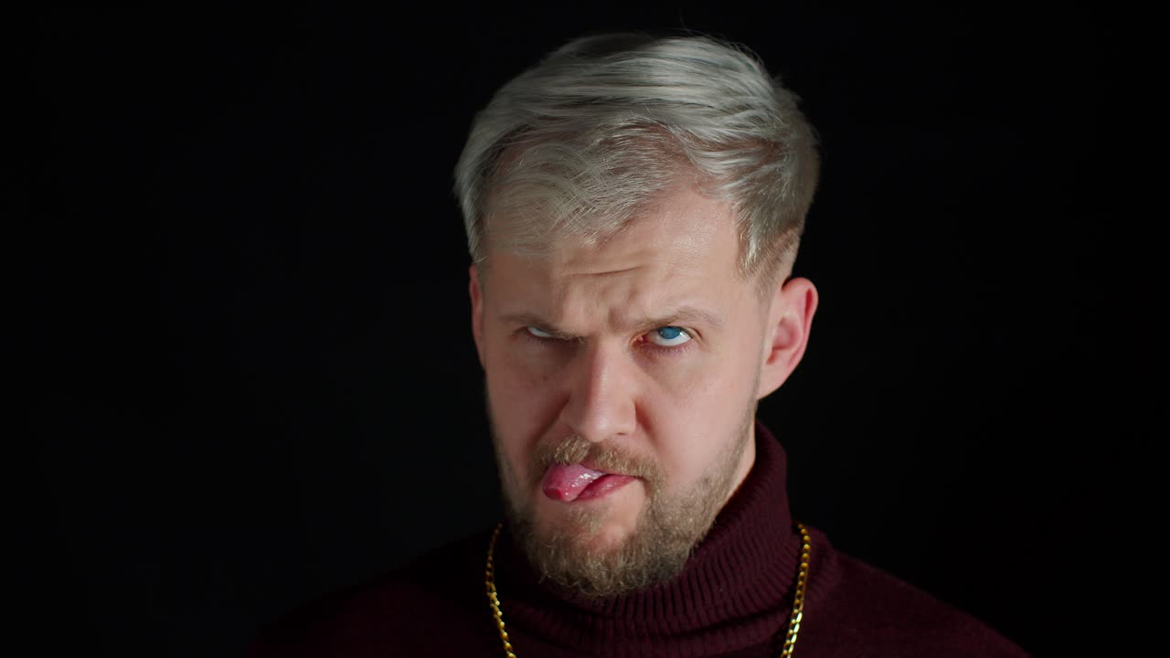 コミックな愚かなスタイリッシュな男が面白い愚かな顔をしている 変な顔をしている 馬鹿をしている 舌を示している 頭のない