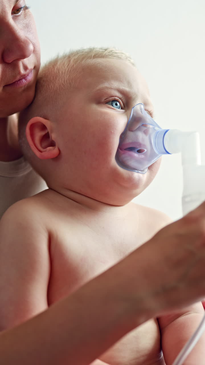 Sick boy receiving respiratory treatment using a nebulizer. Close-up of a boy breathing through an inhalation mask on his face. Therapeutic inhalation of a child at home