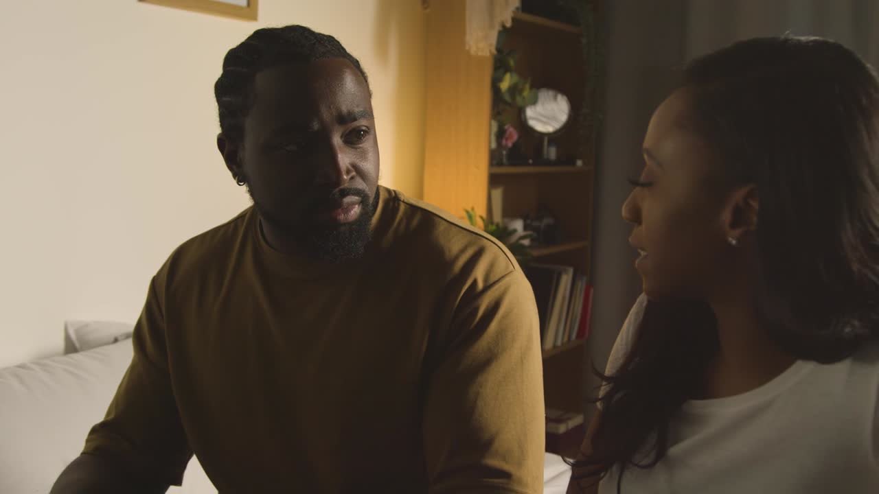 Couple At Home Sitting On Bed At Night Having Argument 2