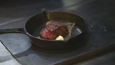 In-Einer-Gusseisernen-Pfanne-Brutzelt-Ein-Großes,-Saftiges-Steak-In-Butter