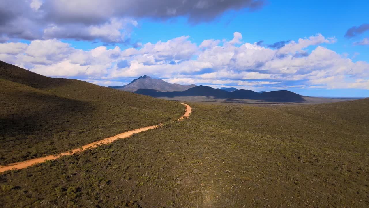 Aerial, distant car driving through vast lush landscape, Western Australia