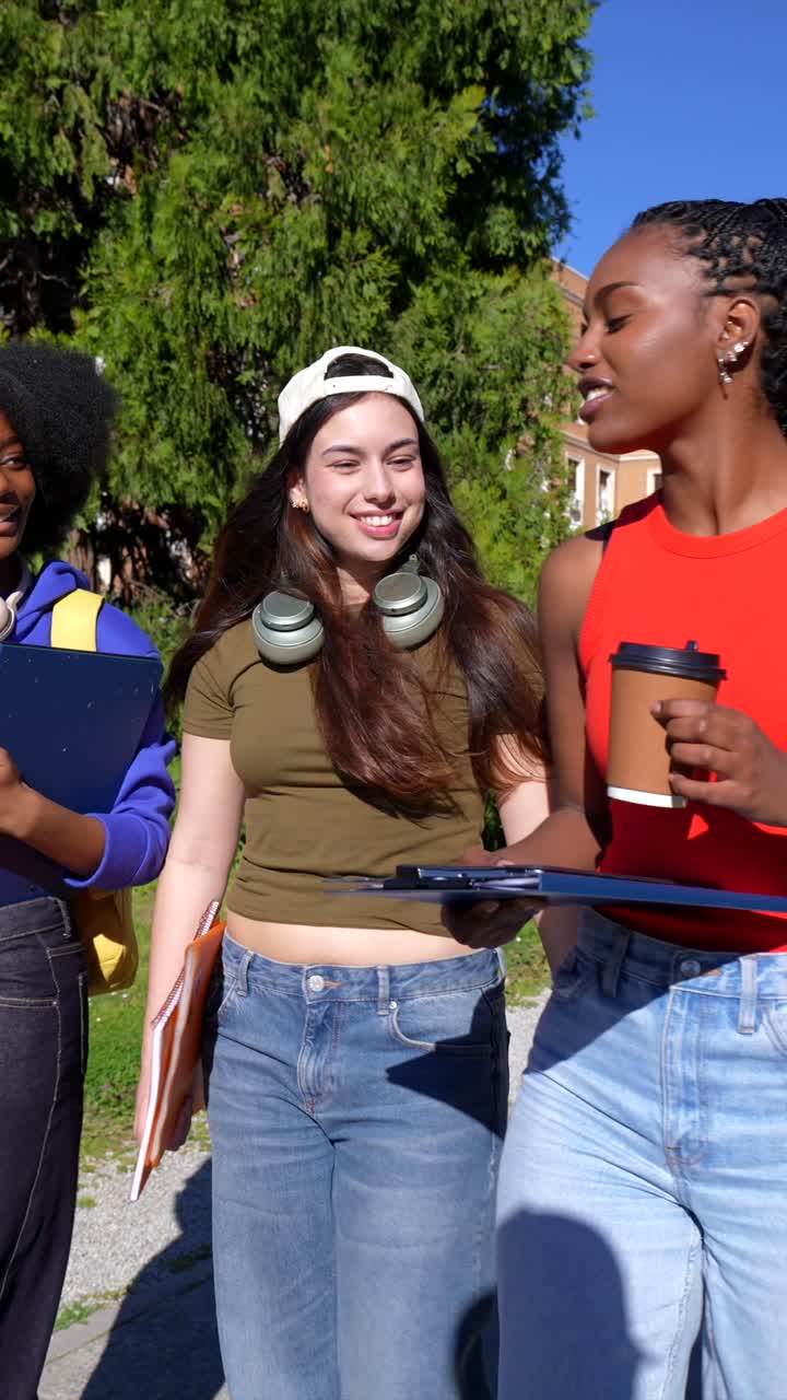 Studentesse sorridenti che socializzano all'aperto in una giornata universitaria soleggiata