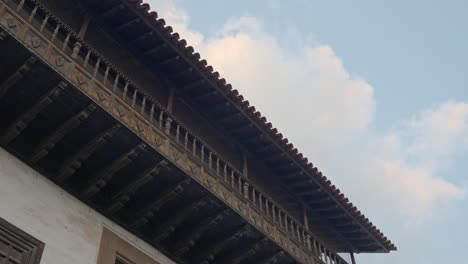 Wooden-Balcony-Terrace-with-Wood-Carving-on-the-Exterior-of-a-House-in-Tenerife-Looking-Up-from-Underneath-with-Sky-Background