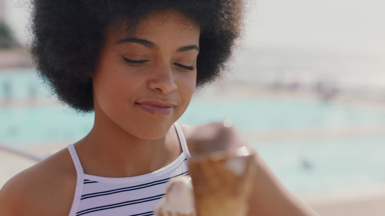 bellissime donne che mangiano gelato sulla spiaggia amiche che si godono deliziosi soft serve che si rilassano in una calda giornata estiva filmati in 4k