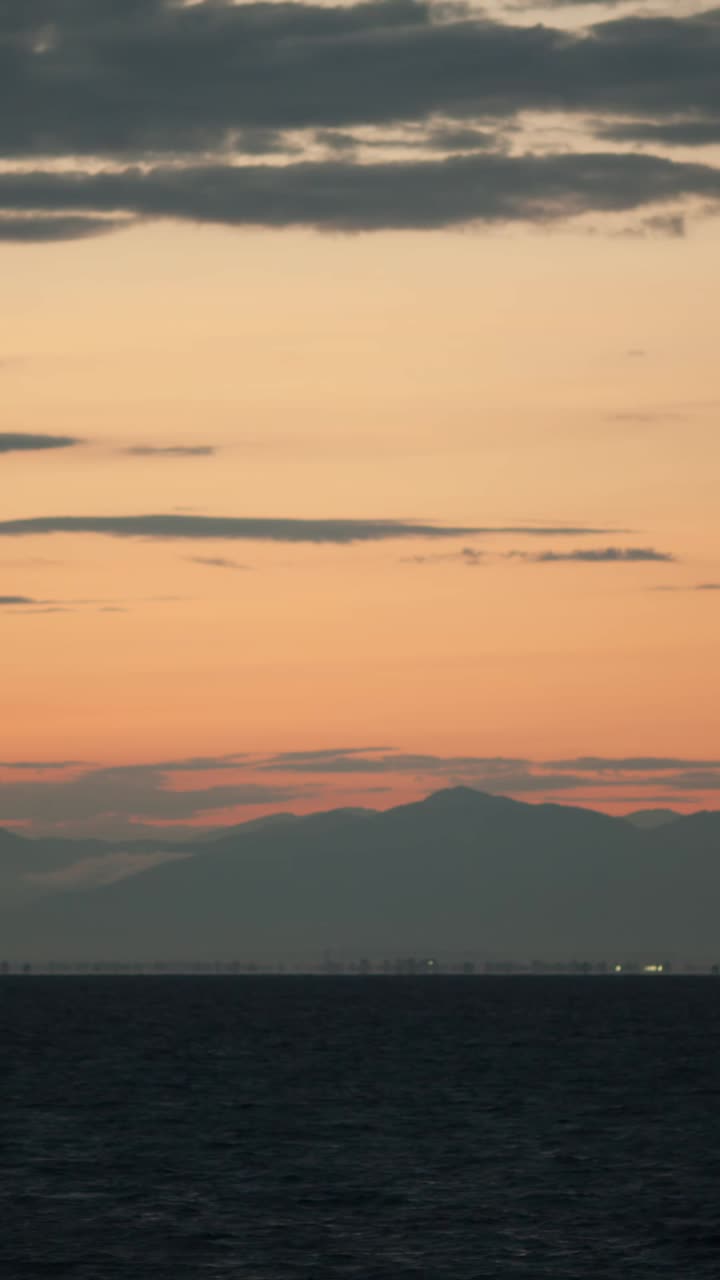 Sunset over the ocean with mountain backdrop