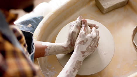 African-american-male-potter-using-potter's-wheel-in-pottery-studio,-slow-motion