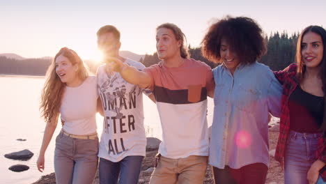 friends laughing and pointing at sunset