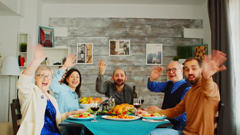 pov shot of family at dinner having a video call with friends