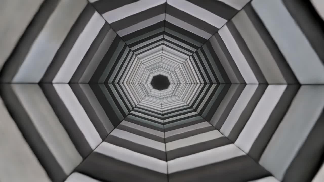 Esagono concentrico pulsante che si sposta verso l'interno dopo il cambio di fotogramma, rivelando bande a strisce sullo schermo.