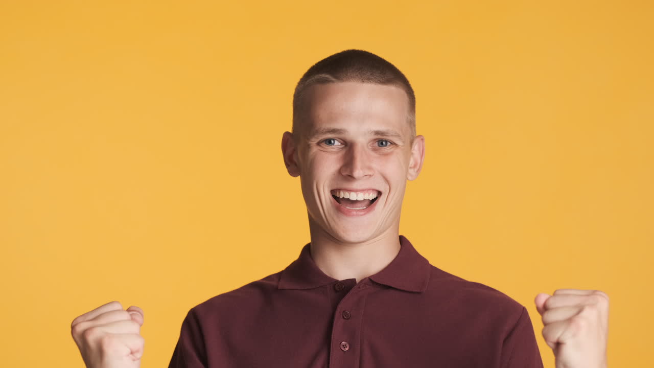 파란 눈 을 가진 백인 십대 가 축하 의 몸짓 을 하고 있다