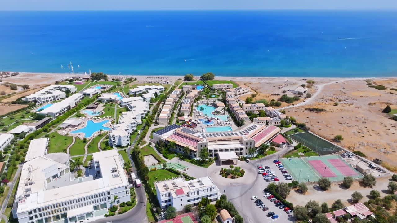 Aerial tracking shot in front of hotels on the coastline of Rhodes, sunny Greece