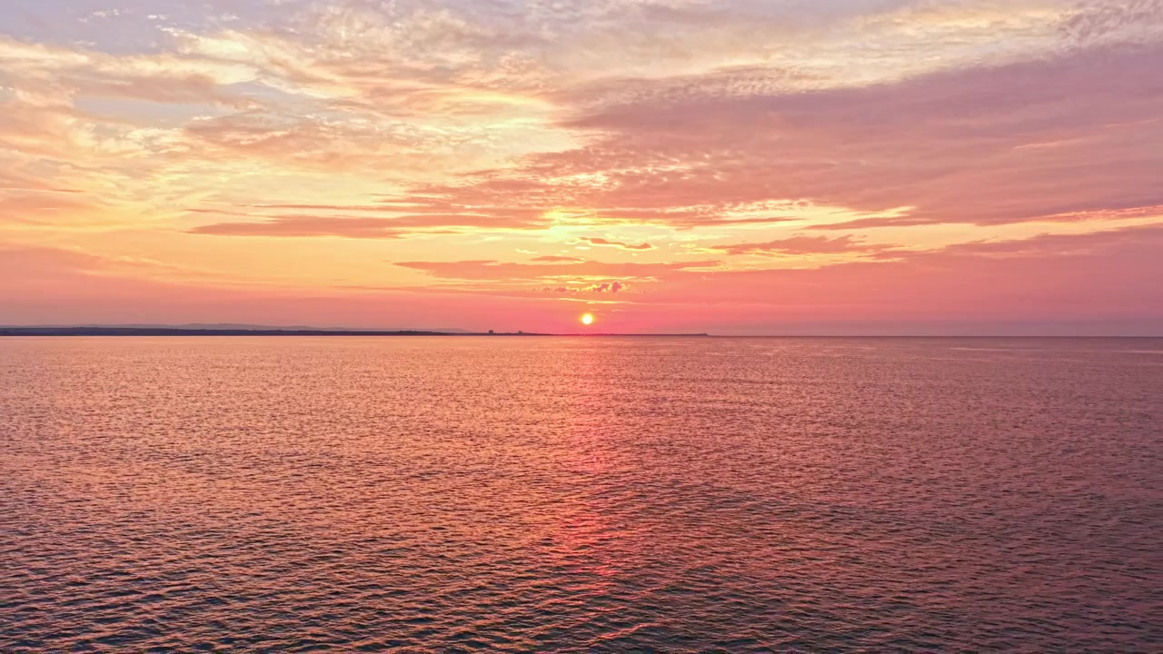 Solnedgang over havet med skyer og farverig himmel sidst på dagen