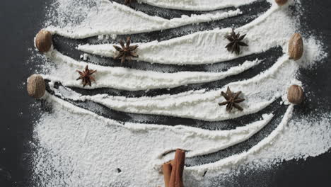 video of christma tree shape in sugar with spices and copy space on black background