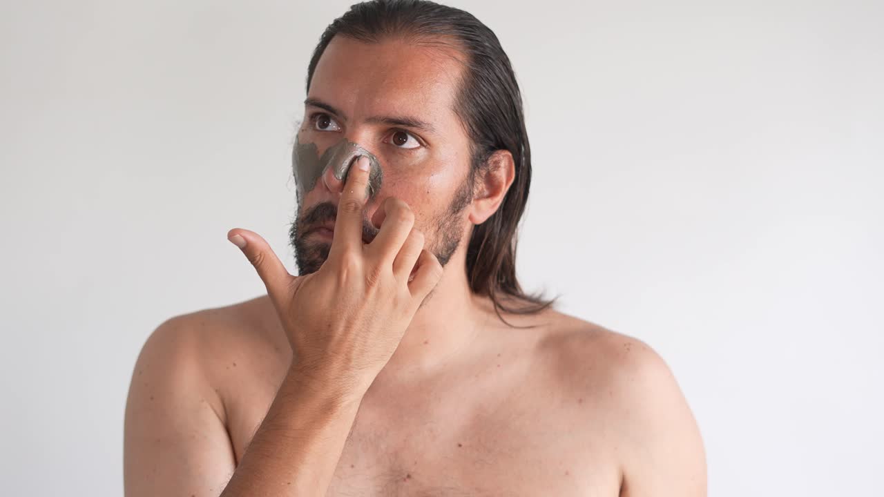남자는 얼굴의 피부를 돌봅니다.