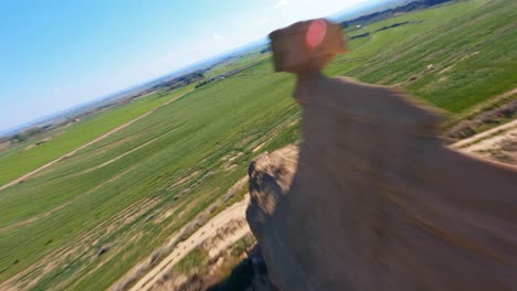 fpv aerial drone flying along a unique rock formation in a scenic landscape