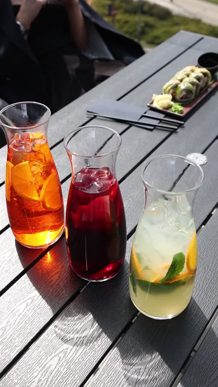Tres bebidas refrescantes y coloridas en una mesa de restaurante al aire libre