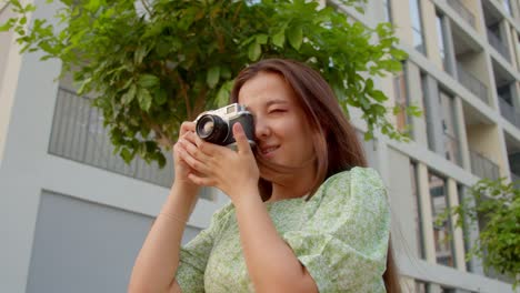 Mujer-Bloguera-De-Viajes-Toma-Fotos-Usando-La-Antigua-Cámara-Soviética-Rusa-Zenit,-Cámara-Lenta-De-4k