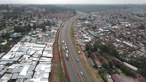 Aerial-view-of-highway-traffic-and-Kibera-slums-in-suburbia-of-Nairobi,-Kenya
