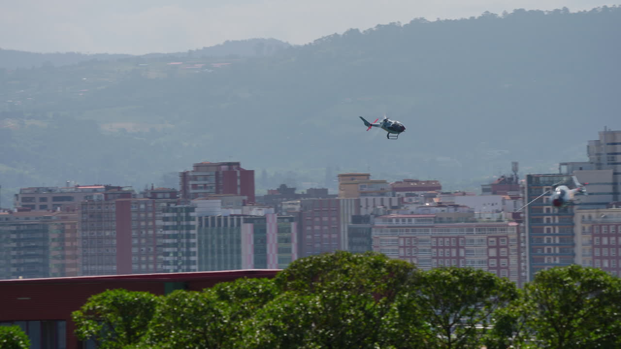 Helicopters flying over a city near a beach