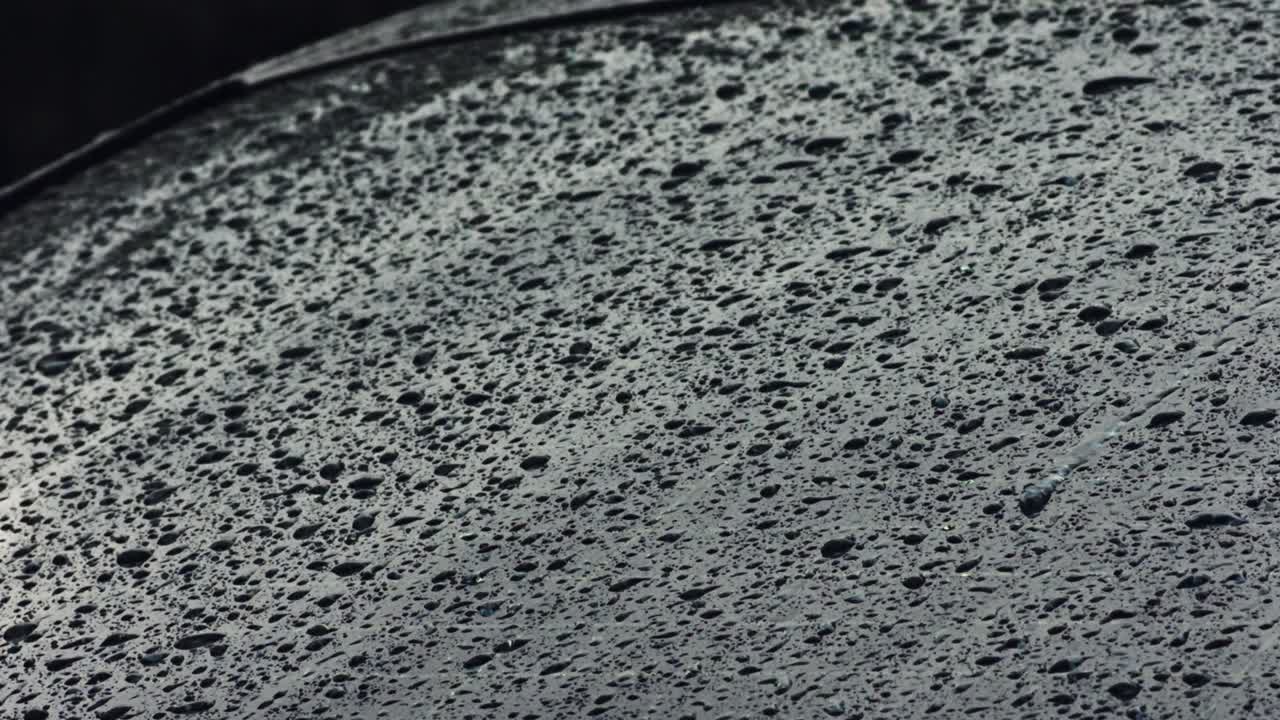 gotas de agua de lluvia ligera cayendo en la ventana exterior del camión en un día oscuro y sombrío