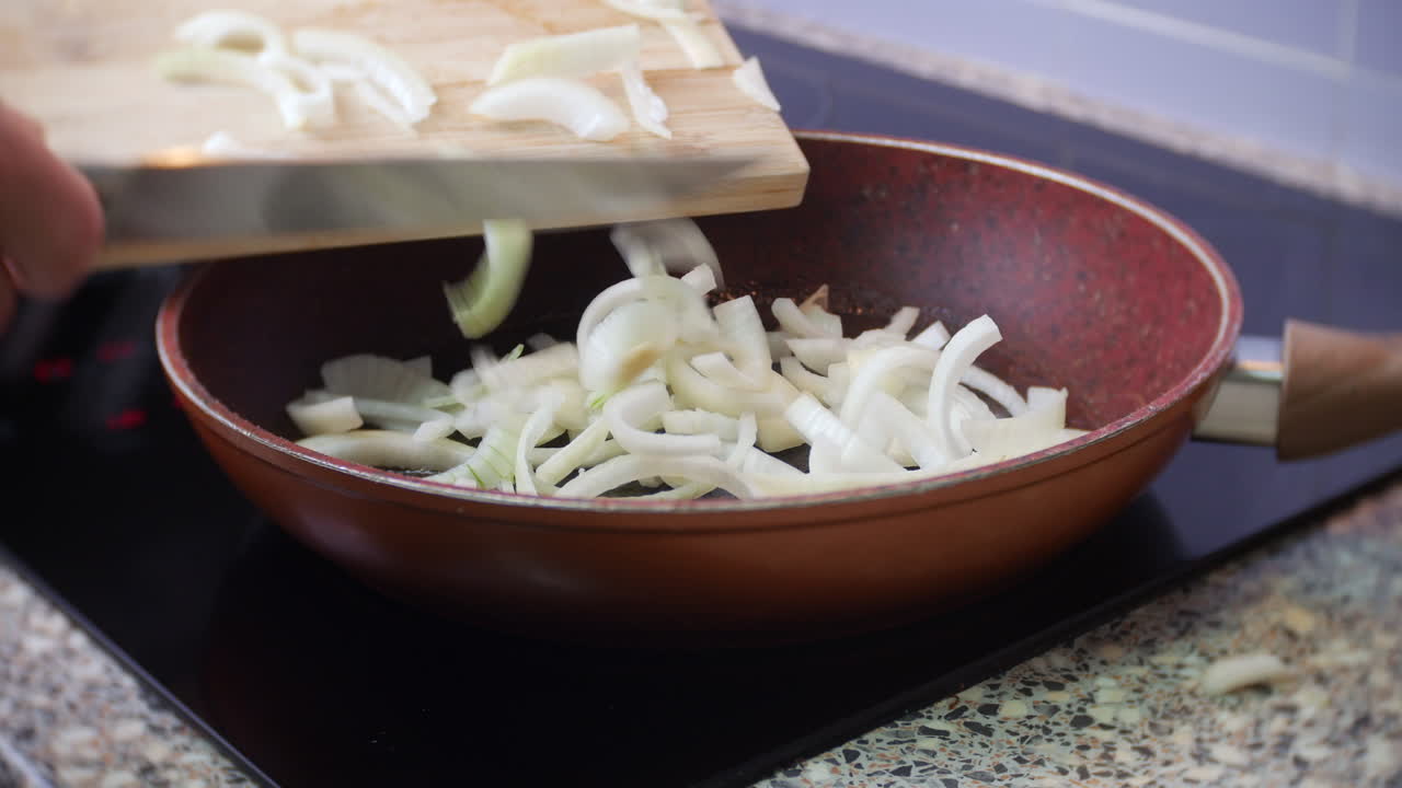 Chopped onions are added to a frying pan