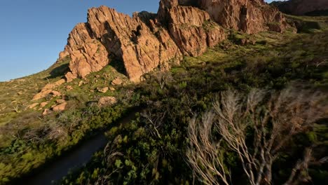 Luftaufnahmen-Von-FPV-Fliegen-über-Die-Wüstenlandschaft-Von-Arizona-In-Richtung-Dramatischer-Felsformationen-Bei-Sonnenuntergang