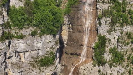 waterfall in seerenbachfälle, amden, with lush green trees and rocky cliffs around
