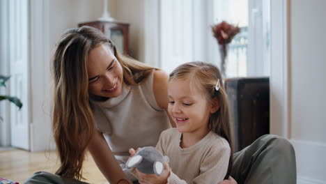 Süße-Familie-Spielt-Häschen-Im-Gemütlichen-Zuhause,-Nahaufnahme.-Positive-Frau-Umarmt-Mädchen