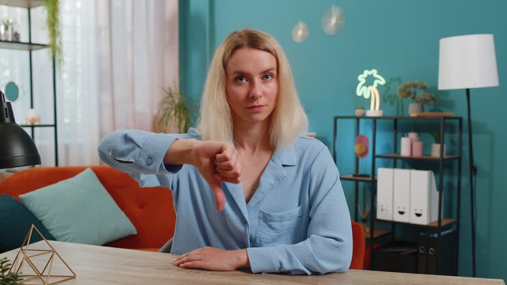 Upset businesswoman showing thumbs down dislike sign gesture expressing discontent disapproval