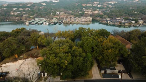 Flug-über-Häuser-In-Einem-Vorstadtviertel-In-Tarrytown,-Austin,-Texas,-Mit-Blick-Auf-Den-Lake-Austin.-Die-Luftaufnahme-Neigt-Sich-Bei-Sonnenaufgang-In-4K