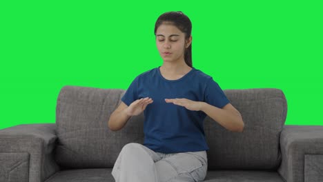 Happy-Indian-teenage-girl-doing-breathe-in-breathe-out-exercise-Green-screen