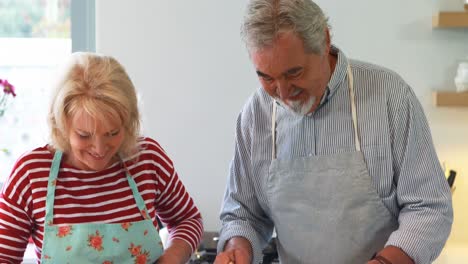 couple preparing salad in kitchen