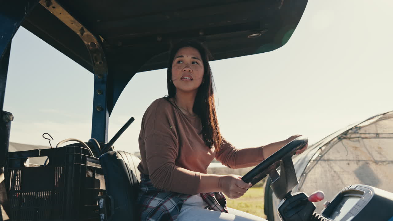 mujer, conduciendo y tractor agrícola en el campo