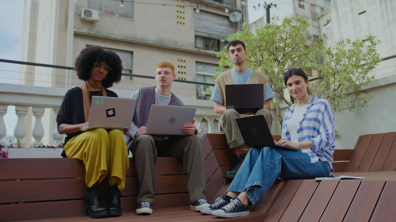 Young Business Team with Laptops Posing on Camera Outdoors in the City
