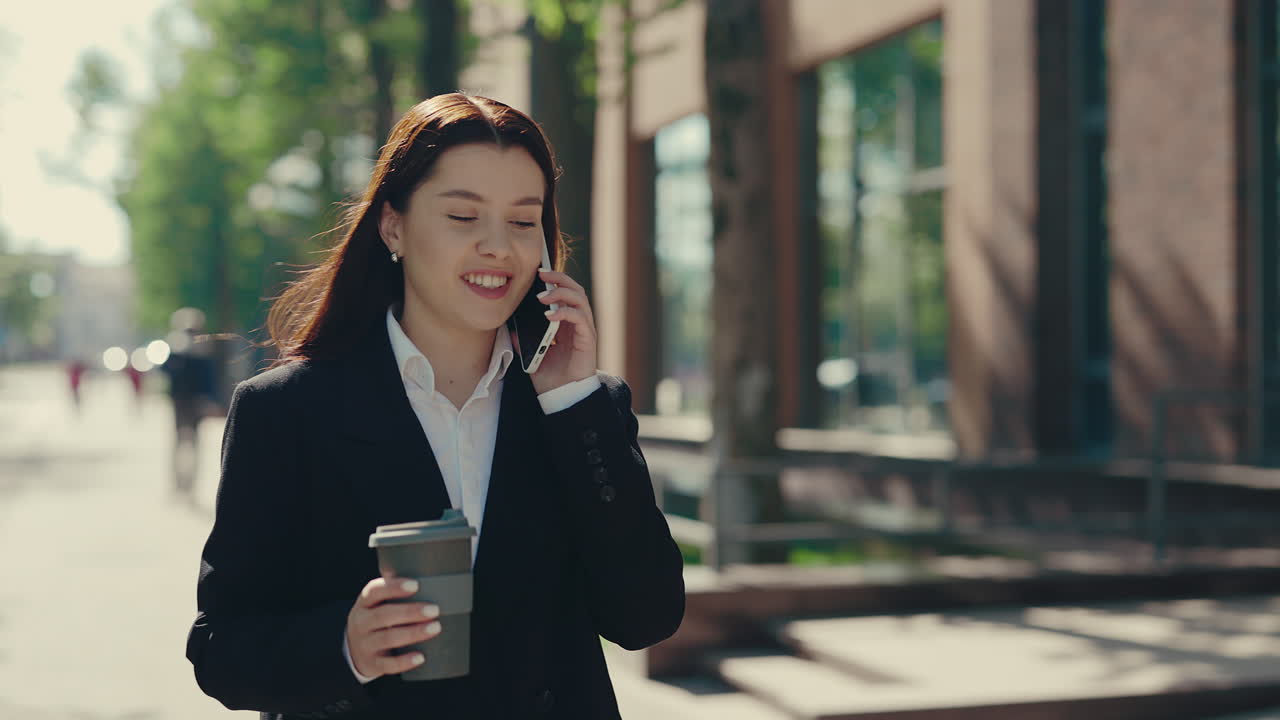 Businesswoman walking and talking on phone outside